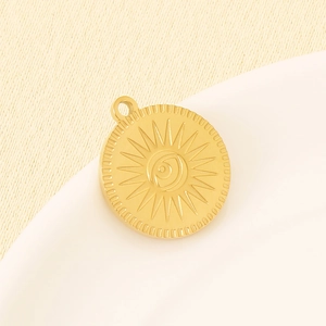 Detailed macro view of an 18K gold-plated stainless steel evil eye charm on ceramic