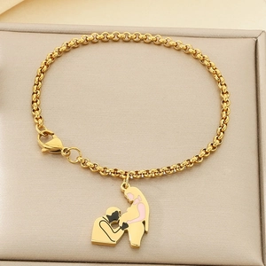 Détail du bracelet chaîne à perles dorées avec pendentif de maternité sur plateau