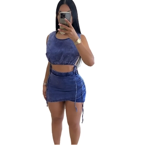 Blue washed denim two-piece set featuring a cropped camisole top and drawstring mini skirt