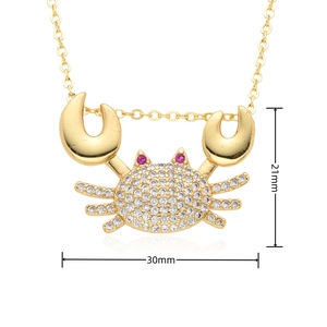 Macro shot of gold crab pendant with micro-pave white zircons and dimensions 30x21mm