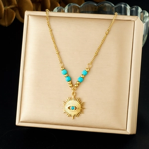 Gold stainless steel sun and eye pendant necklace with turquoise beads on jewelry box