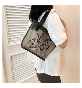 Close-up of black transparent PVC tote bag with butterfly prints and wide shoulder strap