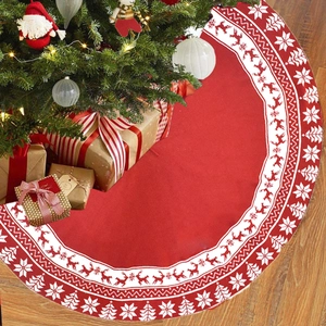 Detail of red knitted Christmas tree skirt with white reindeer and snowflake pattern