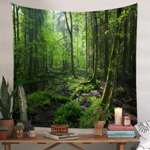 Dettaglio di un arazzo forestale su parete bianca con piante e libri decorativi