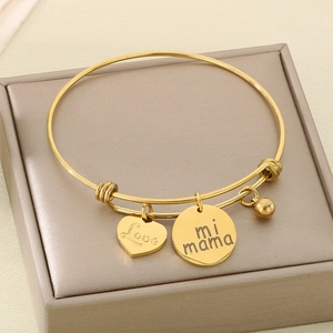 Detail of adjustable gold bracelet with Love heart and mi mama engraved charms