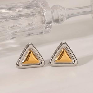 Macro shot of minimalist triangular stud earrings with gold and silver two-tone metal finish