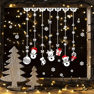 Close-up of white Christmas window stickers with reindeer and snowman on a glass pane