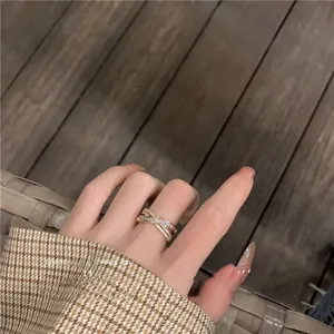 Nahaufnahme eines roségoldenen Überkreuz-Rings mit Zirkonia an einer Hand