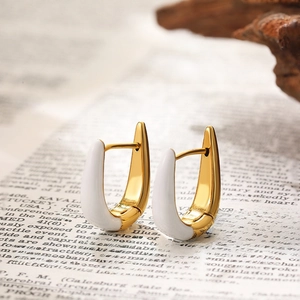 Close-up of modern U-shaped hoop earrings with white enamel and 18K gold plating