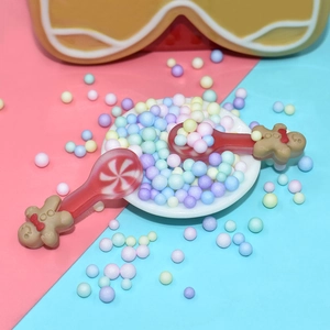 Close-up of decorative gingerbread man spoons with colorful beads for DIY crafts