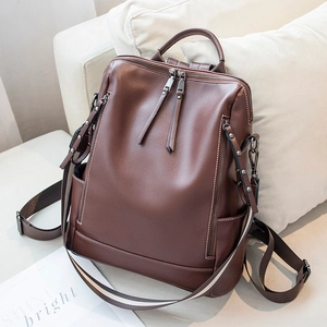 Stylish brown leather backpack for women with spacious compartments on a cozy sofa