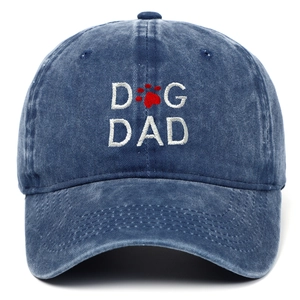 Detailed close-up of DOG DAD embroidery with red paw print on blue washed cotton baseball cap
