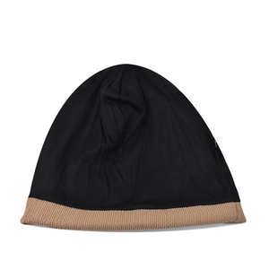 Detail of knit beanie showing two-tone black and camel patchwork and spiral ribbed texture