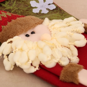 Close-up of 3D Santa Claus figure with white plush beard on oversized linen Christmas stocking