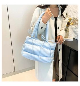 Vue détaillée du sac cabas matelassé à rayures bleues et blanches avec nœuds latéraux