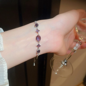 Adjustable silver bracelet featuring purple oval zircon stones on a female wrist