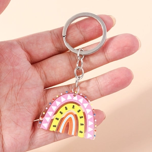 Hand holding a colorful acrylic rainbow keychain with geometric patterns and metal ring