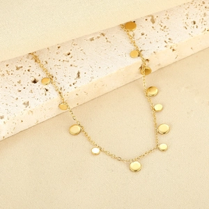 Minimalist gold stainless steel choker with small polished circular disc pendants on travertine
