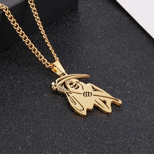 Close-up of golden grim reaper scythe pendant with hip hop skull details on black texture