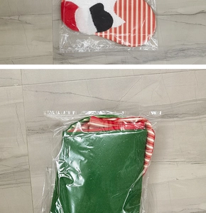 Detail view of two fabric Christmas stockings with cat pattern and stripes in clear packaging