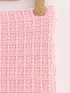 Close-up of pink waffle knit fabric showing premium texture and detailed stitching