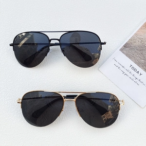 Classic aviator sunglasses in black and gold metal frames on white background