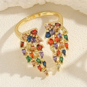 Vue macro d'une bague réglable dorée avec des pierres colorées en forme de feuille