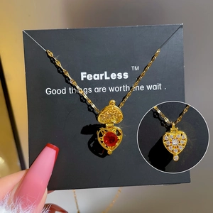 Golden heart locket necklace with zircon pavé and red ruby interior on a sleek chain