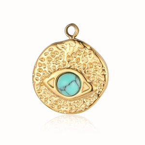 Detail of gold hammered stainless steel evil eye pendant with turquoise stone inlay