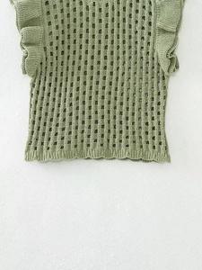 Detail of light green crochet knit vest featuring ruffled flutter sleeves and square hollow texture