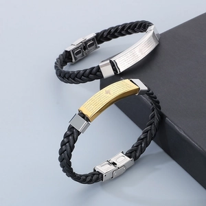 Macro detail of braided leather bracelet with engraved Lord’s Prayer stainless steel plate