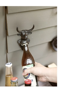 Primer plano de un abridor de botellas de pared vintage de hierro fundido con forma de toro