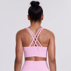 Close-up of pink sports bra featuring cross-back straps and elastic yoga fabric
