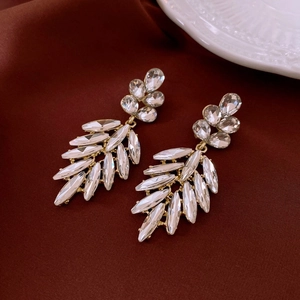 Detailed macro view of leaf shaped tassel earrings with sparkling crystal rhinestones