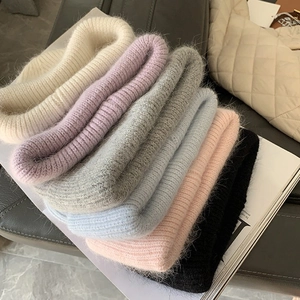 Detailed pile of thick rabbit fur knit beanies in six assorted soft winter colors