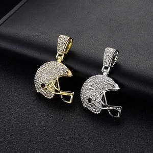 Détail macro de pendentifs casque de football américain en or et argent avec strass