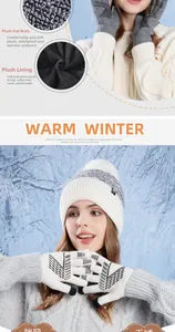 Detail of warm winter set with thick knit pompom hat and touchscreen gloves in snow
