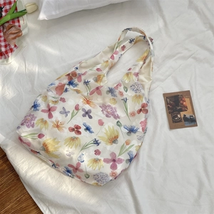 Detail of floral mesh tote bag with colorful flower patterns on creamy fabric
