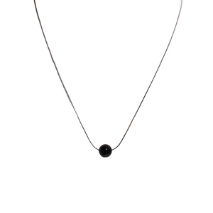 Minimalist silver chain necklace featuring a polished black agate bead pendant on white background
