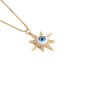Détail de la chaîne dorée et du pendentif œil bleu avec des zircons brillants incrustés