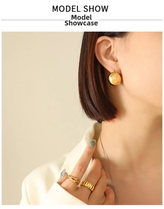 Chic gold-plated U-shaped earrings and textured statement rings worn by model