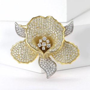 Detailed close-up of a floral brooch with micro-pave crystals and gold accents