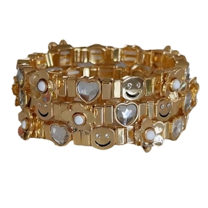 Gold elastic bracelet set featuring smiley face, heart and flower charms for women