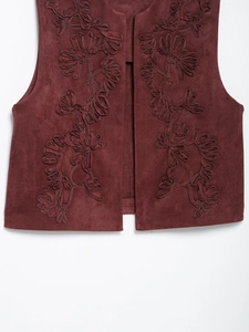 Detailed embroidery on dark red faux suede vest featuring intricate floral patterns