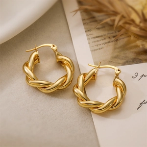 Detailed close-up of 18K gold plated twisted hoop earrings with a polished metal texture