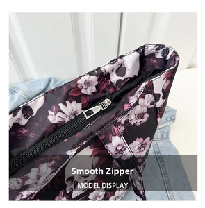 Detail of the smooth silver zipper and floral skull pattern on a large tote bag