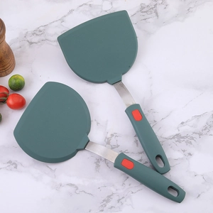 Deep green silicone spatula with stainless steel handle on white marble background