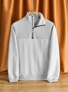 Dettaglio maglione bianco a treccia con colletto a zip e texture geometrica