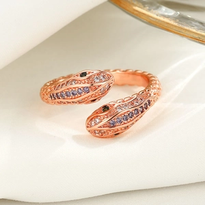 Detail of rose gold double-headed snake ring with micro-paved purple and green crystals