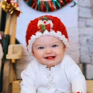 Detailed view of baby Christmas knit hat with snowman 3D decoration and festive red white pattern